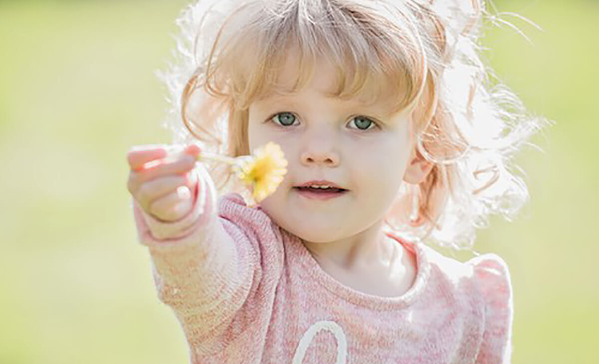 little girl holding flower